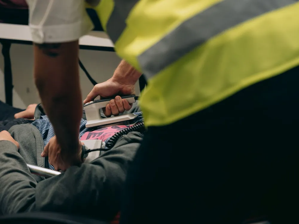Einsatzkraft bedient einen Defibrillator während einer Notfallübung