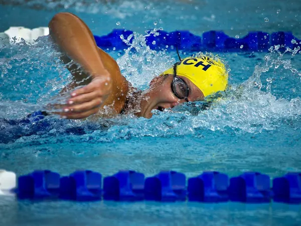Schwimmerin beim Kraulen zwischen Bahnentrennleinen